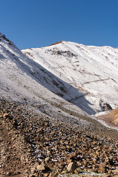 Vertical shot of a snow-dusted trail leading to Travelers Pass in the direction of Lenin Peak in the Pamir Mountains