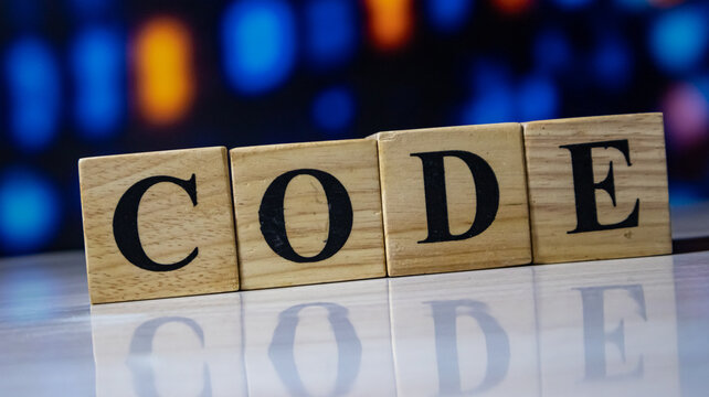Code word spelled with wooden blocks on shiny table.