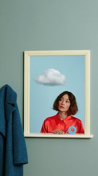 Small storm cloud raining on a window sill, with a woman holding a roll of blue tape and a deadpan expression for weather preparation and surreal creative concepts
