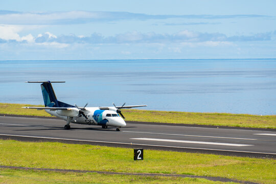 FAIAL, AZORES, PORTUGAL - JULY 19, 2026: A SATA Air Acores De Havilland Canada Dash 8 turboprop aircraft taxis along the coastal runway at Faial Airport, framed by the blue Atlantic Ocean