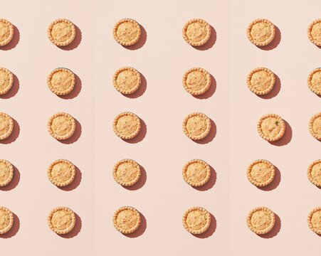 Savoury miniature tartlets with flaky pastry and creamy filling arranged in a precise grid on a blush background for food retail and catering
