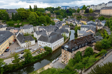 Fototapeta premium Panoramic view of Luxembourg City with the historic church, old town architecture, and the Alzette River winding through the valley
