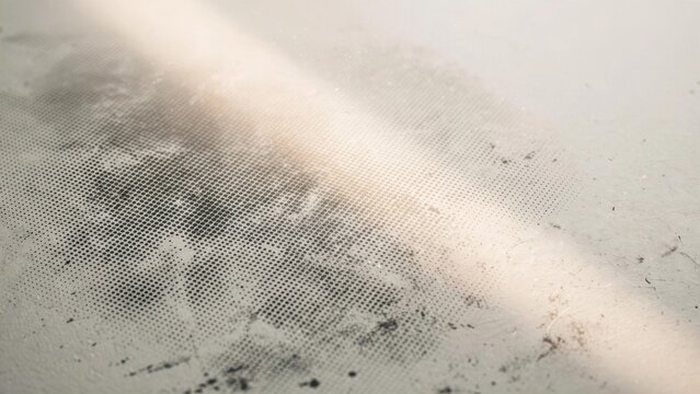Close-up abstract of textured surface with faint lines, distressed marks, and soft light