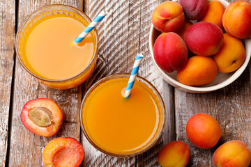 Apricot juice in glasses and fresh fruits on wooden table, flat lay © New Africa