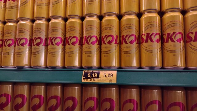 ITABIRA, BRAZIL - AUGUST 26, 2026: Yellow cans of Skol beer displayed on supermarket shelves with price tags