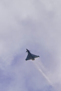 Eurofighter Typhoon jet fighter plane doing a steep climb on a cloudy day with afterburners engaged