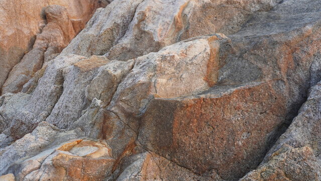 Close-up view of warm-toned, weathered granite rock faces with detailed geometric fractures.