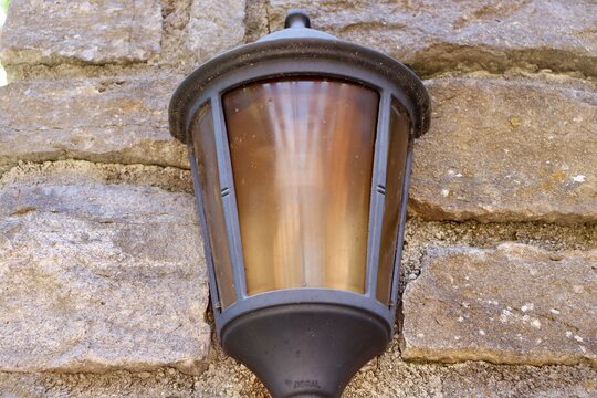 A close view of the light fixture on the brick wall.