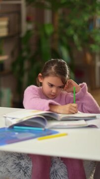 Young girl doing homework with adult assistance
