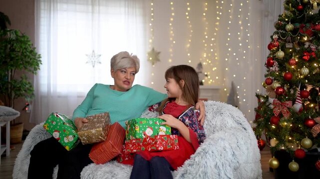 Grandmother and granddaughter happily exchanging christmas gifts