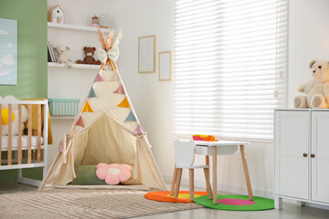 Cute baby room interior with comfortable crib, wigwam and other toys © New Africa