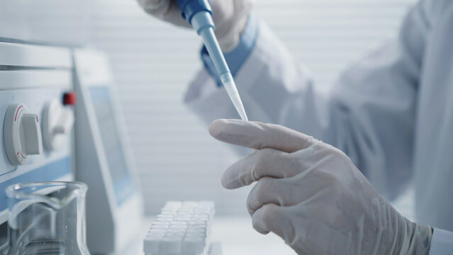 Laboratory Scientist Conducting Precise Medical Research with Pipette
