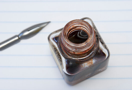 open red ink bottle and pen nib