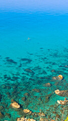 Fototapeta premium Persona su stand up paddle nel mare cristallino e turchese di Tropea
