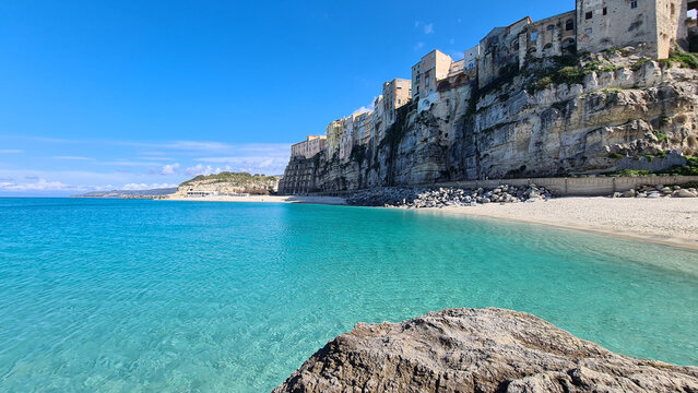 Spiaggia della Rotonda e borgo di Tropea a picco sul mare turchese cristallino