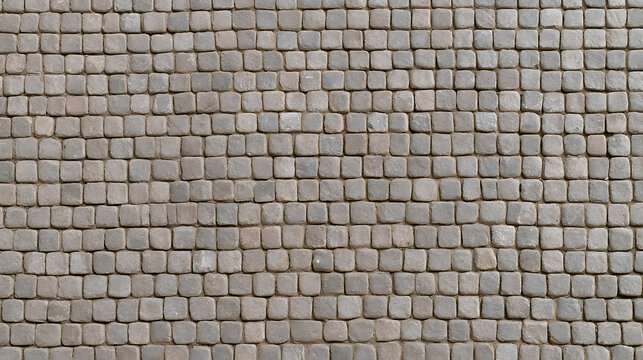 A detailed close-up shot of an old traditional stone cobblestone pavement texture pattern with grey blocks forming a durable vintage surface