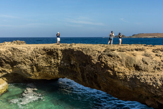 Tourists exploring the Natural Bridge at Arikok National Park in Aruba
