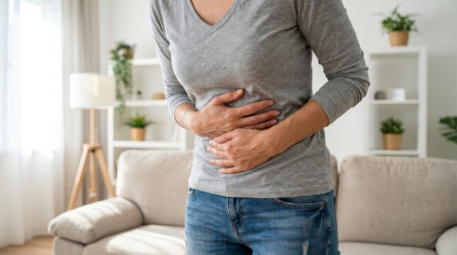 Young woman experiencing abdominal pain and digestive discomfort while standing.
