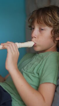 A little boy learns to play the flute at home, practicing with focus and enthusiasm in a cozy, warm setting. A charming scene of early musical exploration, creativity, and childhood growth.
