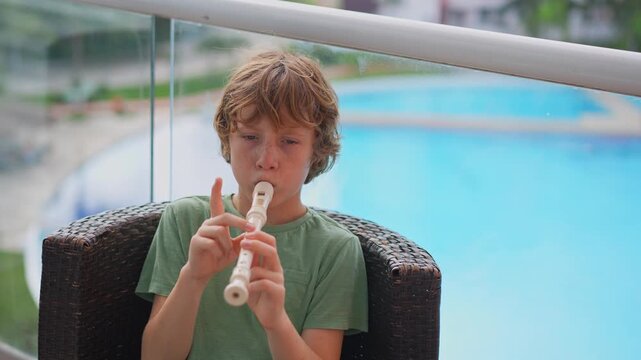 A little boy learns to play the flute at home, practicing with focus and enthusiasm in a cozy, warm setting. A charming scene of early musical exploration, creativity, and childhood growth.