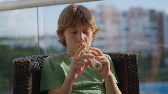 A little boy learns to play the flute at home, practicing with focus and enthusiasm in a cozy, warm setting. A charming scene of early musical exploration, creativity, and childhood growth.