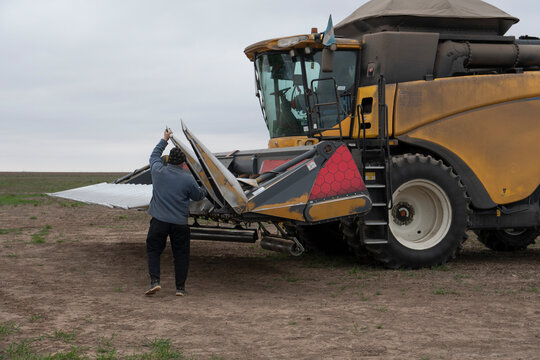 Operario preparando m&aacute;quina trilladora y reja para recolecci&oacute;n de ma&iacute;z en campo argentino