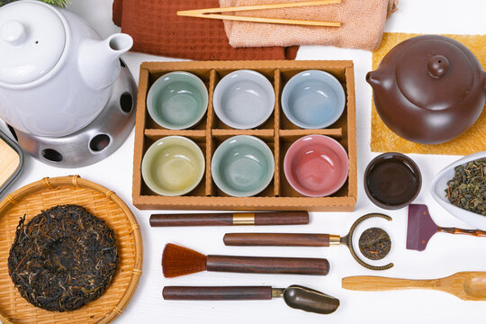 Traditional chinese tea ceremony set with yixing clay teapot and puerh tea cake. Authentic asian tea culture accessories arranged on tabletop. Flatlay of ceramic cups and tea tools