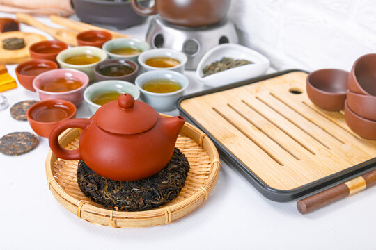 Traditional Chinese tea ceremony with yixing clay teapot and puerh tea on bamboo chaban tray. Authentic Asian tea culture set with small ceramic cups for aromatic herbal beverage serving