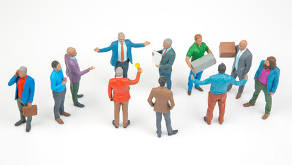 Fototapeta premium Miniature people gathered in a group discussing and sharing items in a simple setting