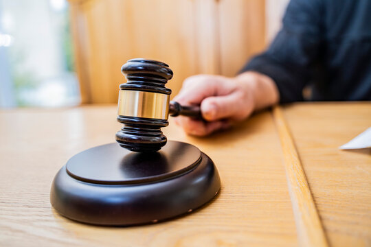 Macro Close-up of Judge's Gavel and Sound Block on Courtroom Table