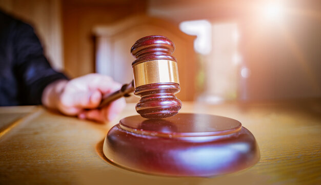 Macro Close-up of Judge's Gavel and Sound Block on Courtroom Table