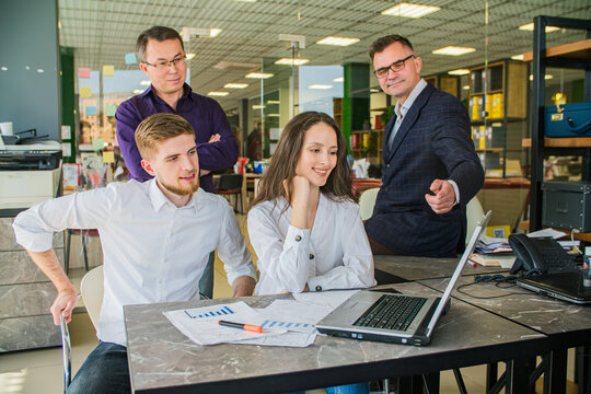 Business Team Working Together on Laptop and Charts in Office