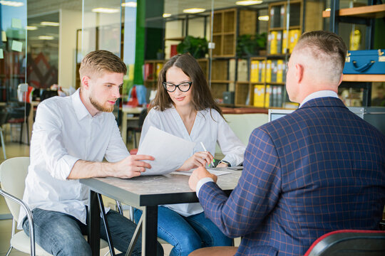 Young Couple Signing Documents with Financial Advisor in Office Meeting