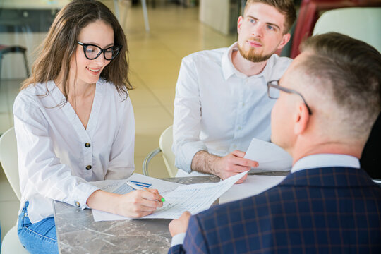 Young Couple Signing Documents with Financial Advisor in Office Meeting