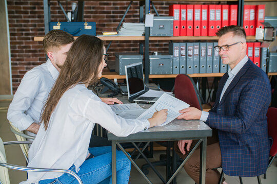 Young Couple Signing Documents with Financial Advisor in Office Meeting