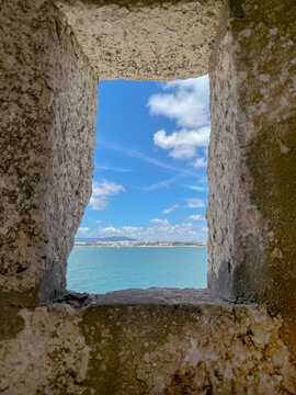 stone window frames a sunny view of blue sea and sky