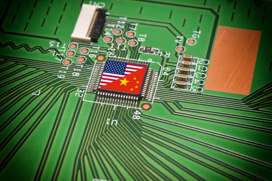 China and USA flags on a microchip of an electronic card. Concept representing the global battle for microchip production and technological supremacy.