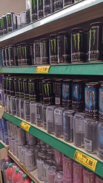 ITABIRA, BRAZIL - AUGUST 26, 2026: Cans of Monster Energy drink on supermarket shelves with promotional price tags