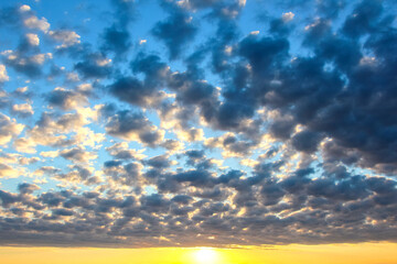 Fototapeta premium Colorful clouds in the sky at sunset over a wide landscape with changing light