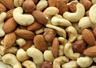 Obraz premium Detailed view on almond and cashew nuts in big pile on table close up