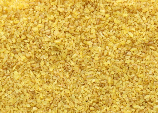 Detailed view on bulgur cereal grains in big pile on table close up