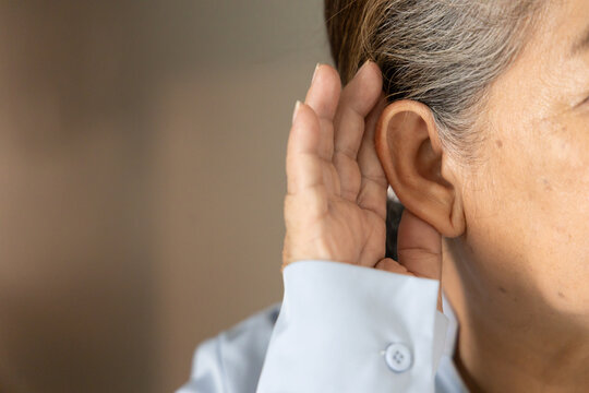Ear of asian senior, late adult woman listening with worried expression and bad feeling, concept image for hard of hearing, hearing problem, body parts closeup shot indoor scene