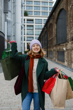Happy woman holding gift bags enjoying winter shopping