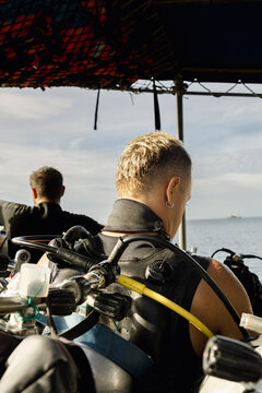 Anonymous scuba diver preparing gear on dive boat in Thailand