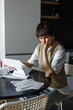 Young tense and concentrated woman checking financial documents