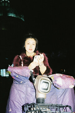 Person Sitting on an Electric Scooter at Night