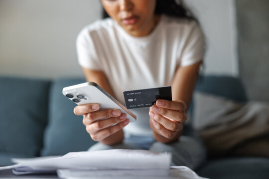 Obscure face of woman paying with credit card on mobile application