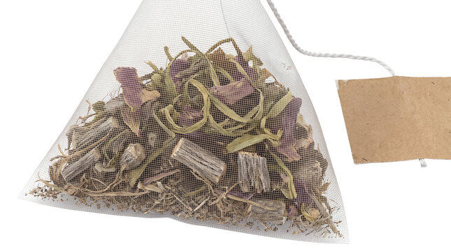 Pyramid tea bag with herbal loose leaf blend, organic mesh sachet with brown paper tag, premium botanical tea infusion isolated PNG with Transparent Background