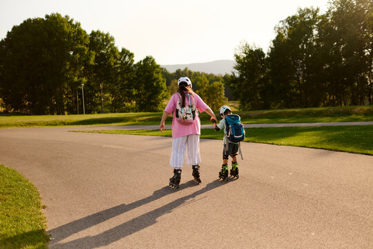 Mother Holding Son's Hand While Roller Skating