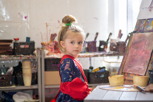 Little child draws on an easel in an art workshop